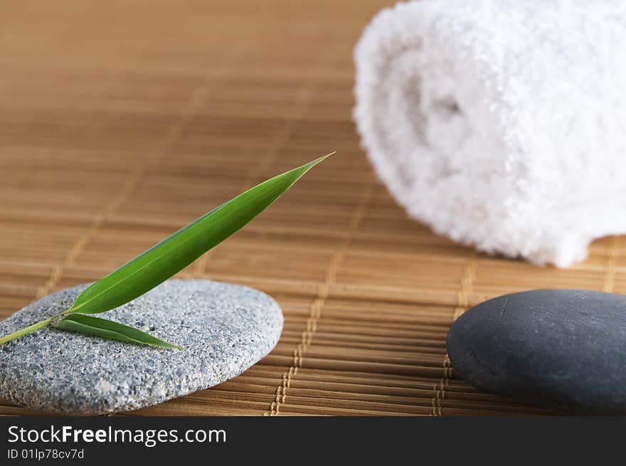 Close up of peddles bamboo leaf and towel on a bamboo mat. Close up of peddles bamboo leaf and towel on a bamboo mat