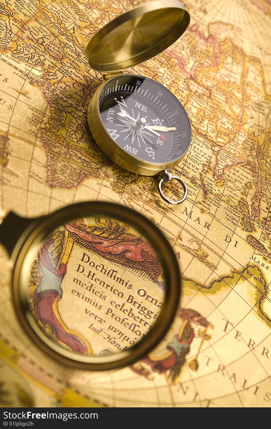 A beautiful golden compass and old magnifier. A beautiful golden compass and old magnifier