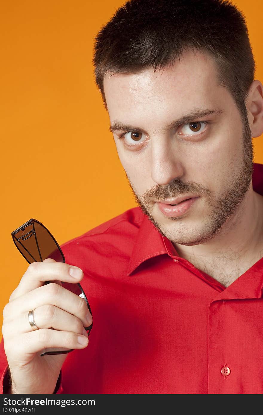 Young man with sunglasses in hand