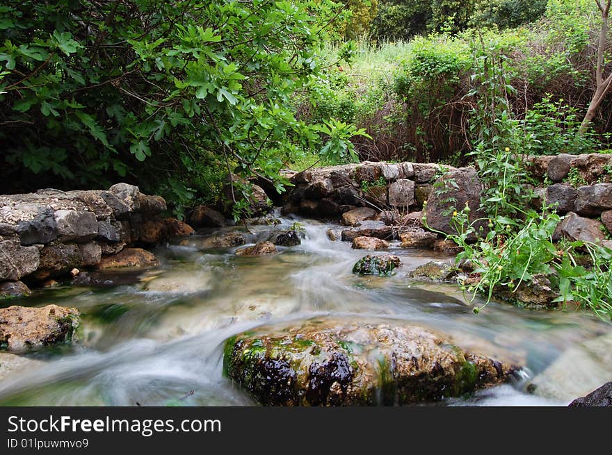 The flow of a river stream - long exposure. The flow of a river stream - long exposure