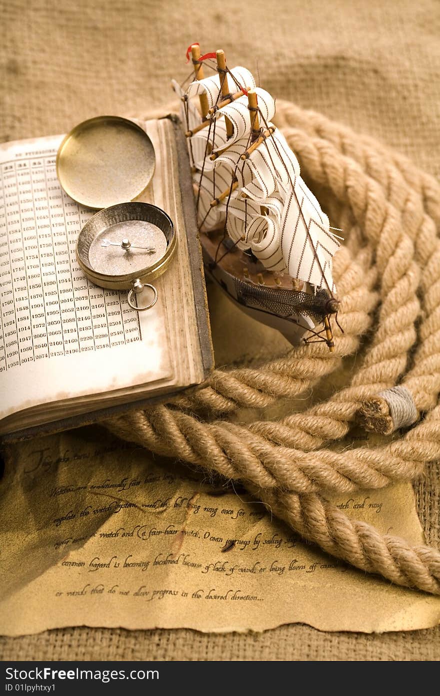 A beautiful golden compass and old rope. A beautiful golden compass and old rope