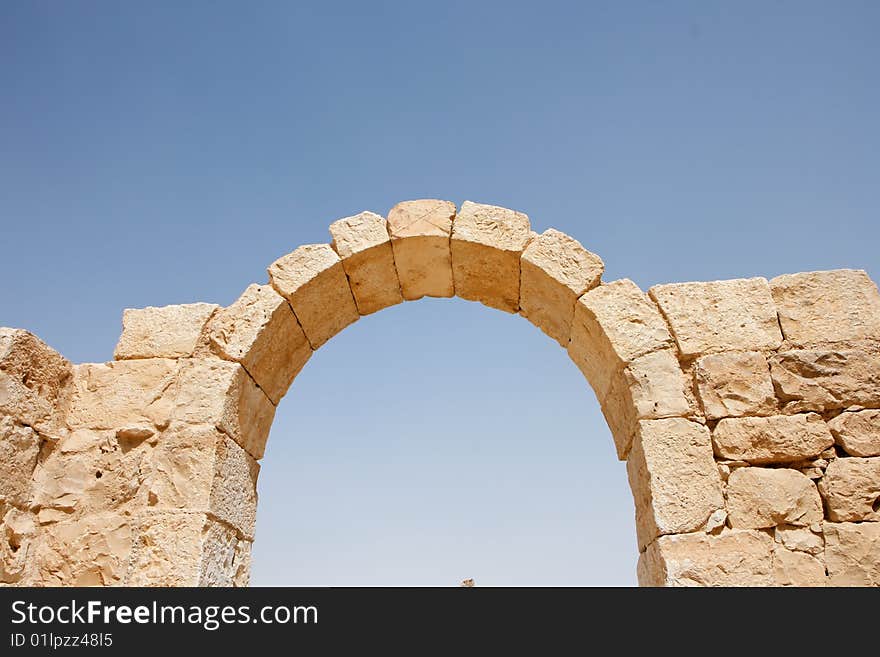 Ruins of ancient stone arch on sky background