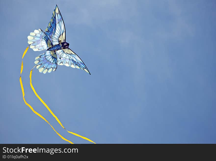 Blue kite arcing against the sky