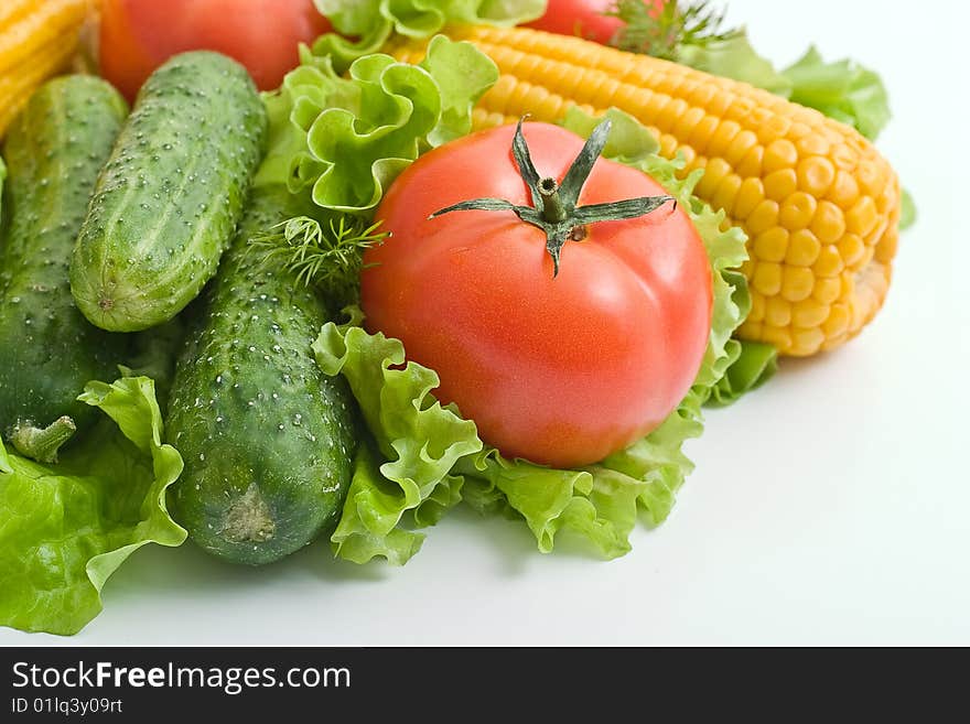 Vegetables on light background: tomatoes, cucumbers, corn on the leaves of lettuce. Vegetables on light background: tomatoes, cucumbers, corn on the leaves of lettuce.