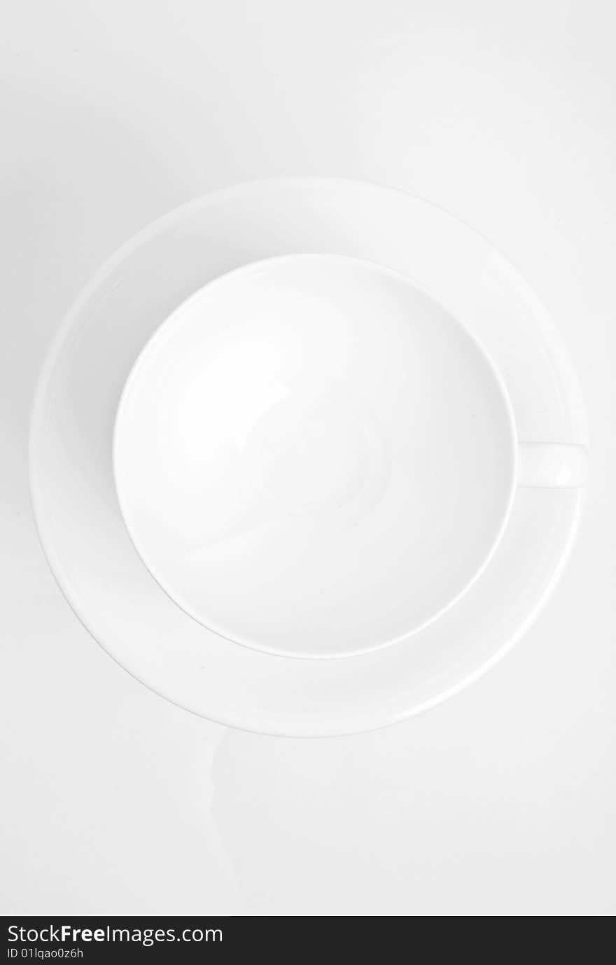 Empty white cup on white saucer