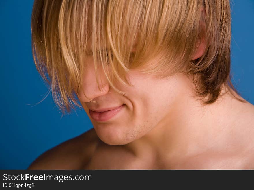 Confused blond man covering his face