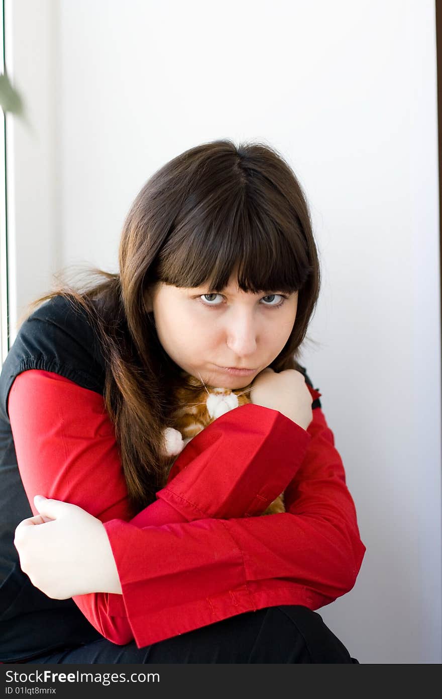 A girl holds a red toy-kitten. A girl holds a red toy-kitten