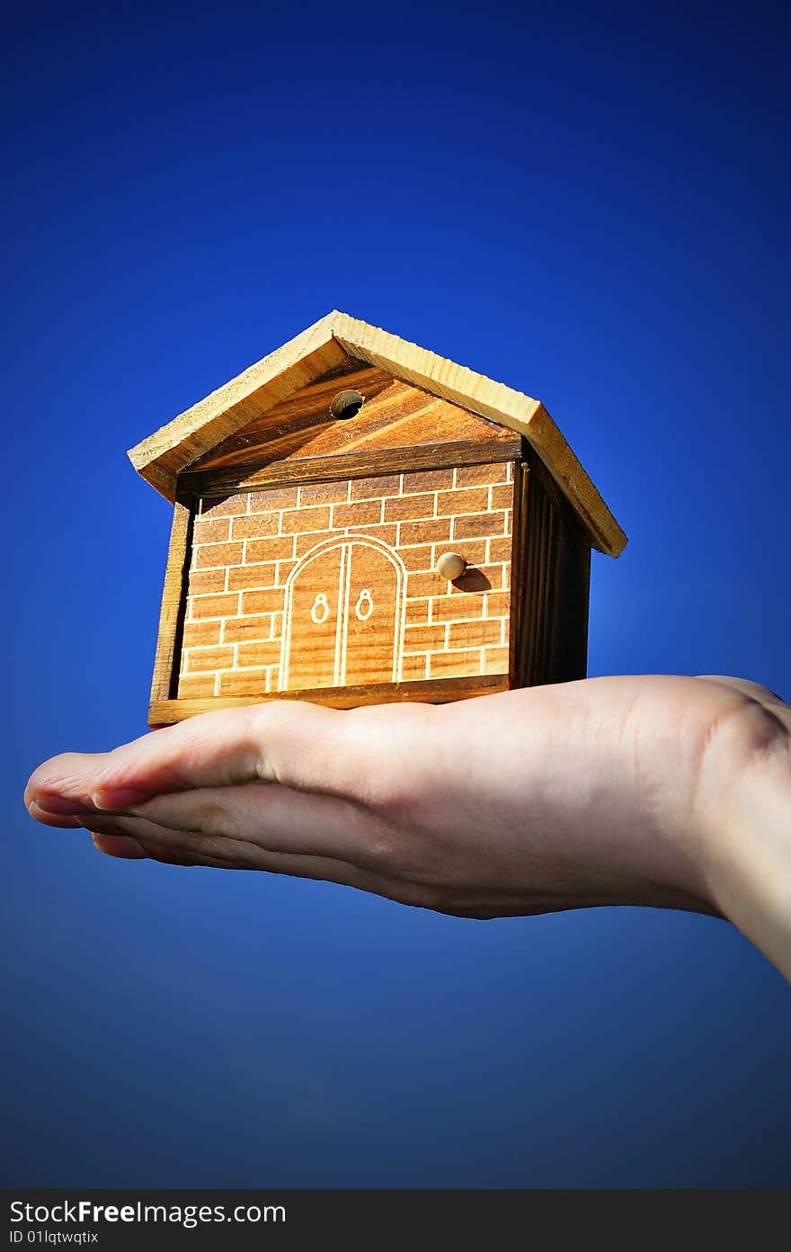 The house in human hand with blue sky. The house in human hand with blue sky