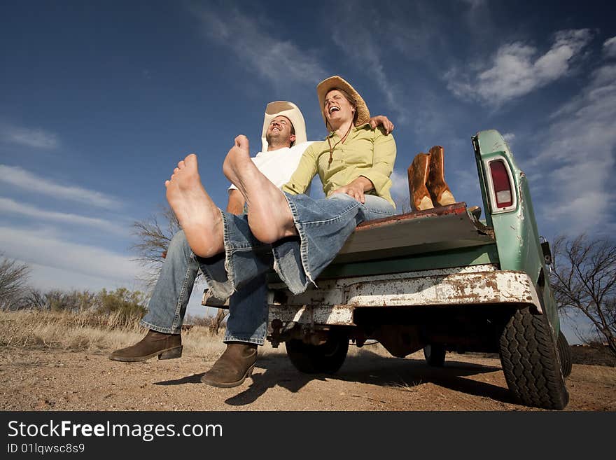 Cowboy and woman on pickup truck