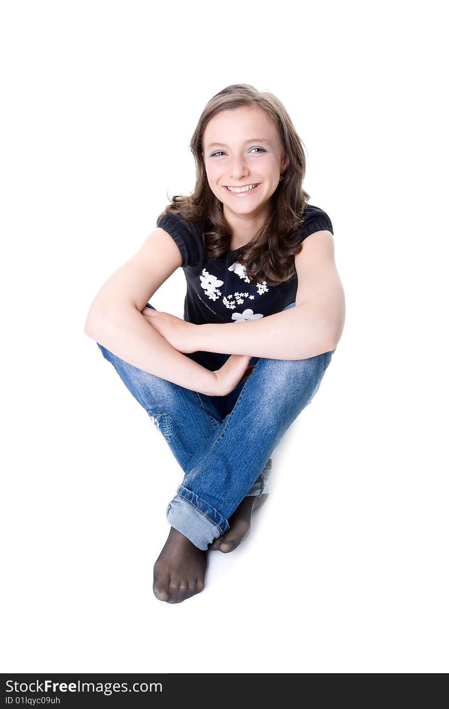 The happy girl sits on a white background