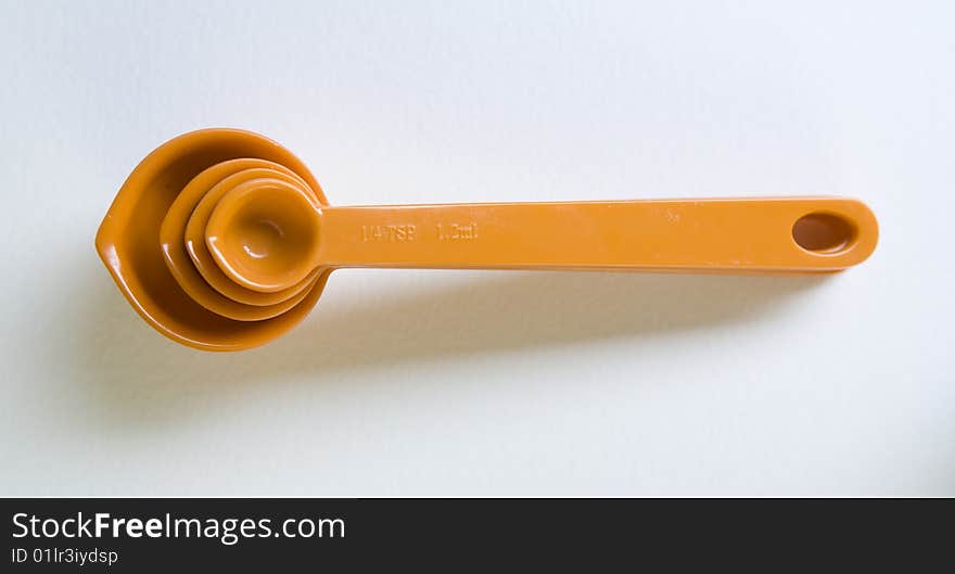 Orange measuring spoons, stacked