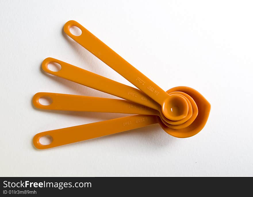 Orange measuring spoons, stacked