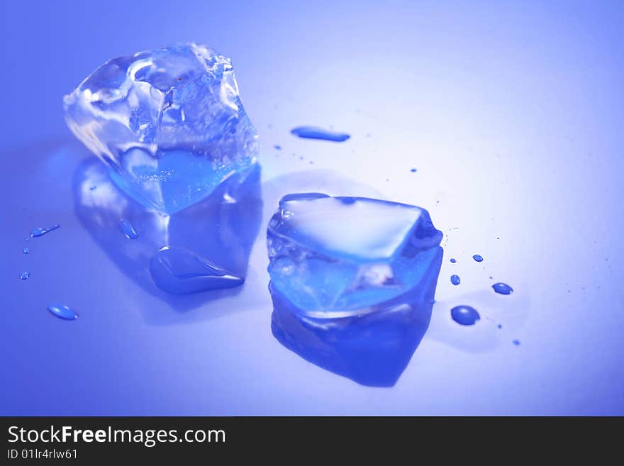 A image of Blue toned ice cubes on blue surface.