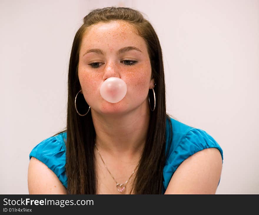 Girl blowing a pink bubble. Girl blowing a pink bubble