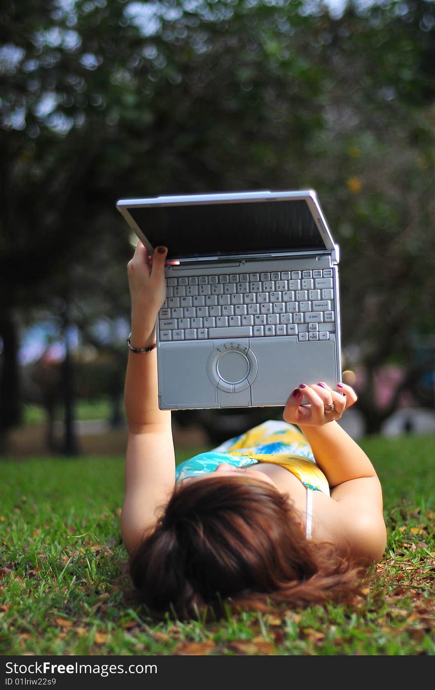 Woman using wireless device in the park. Woman using wireless device in the park.