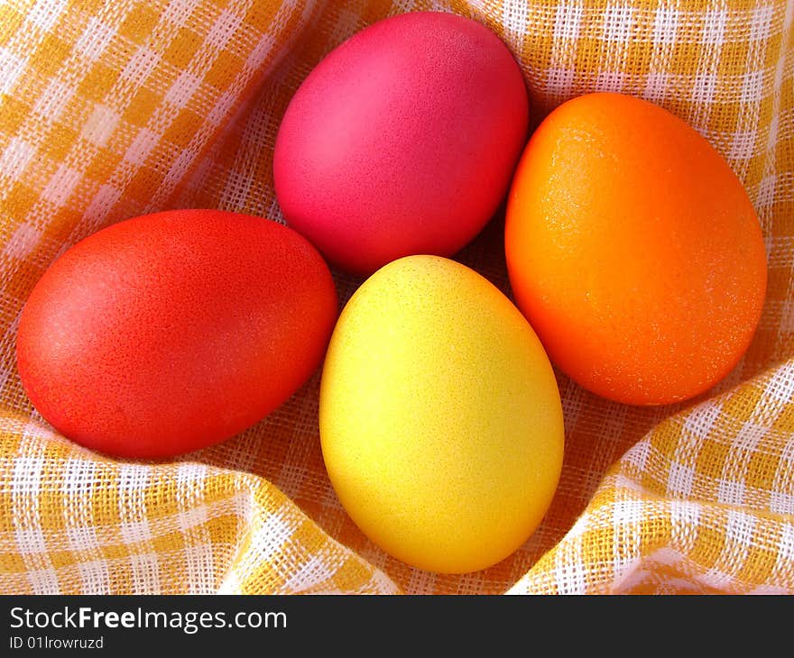 Traditional color Easter eggs on yellow checkers tablecloth