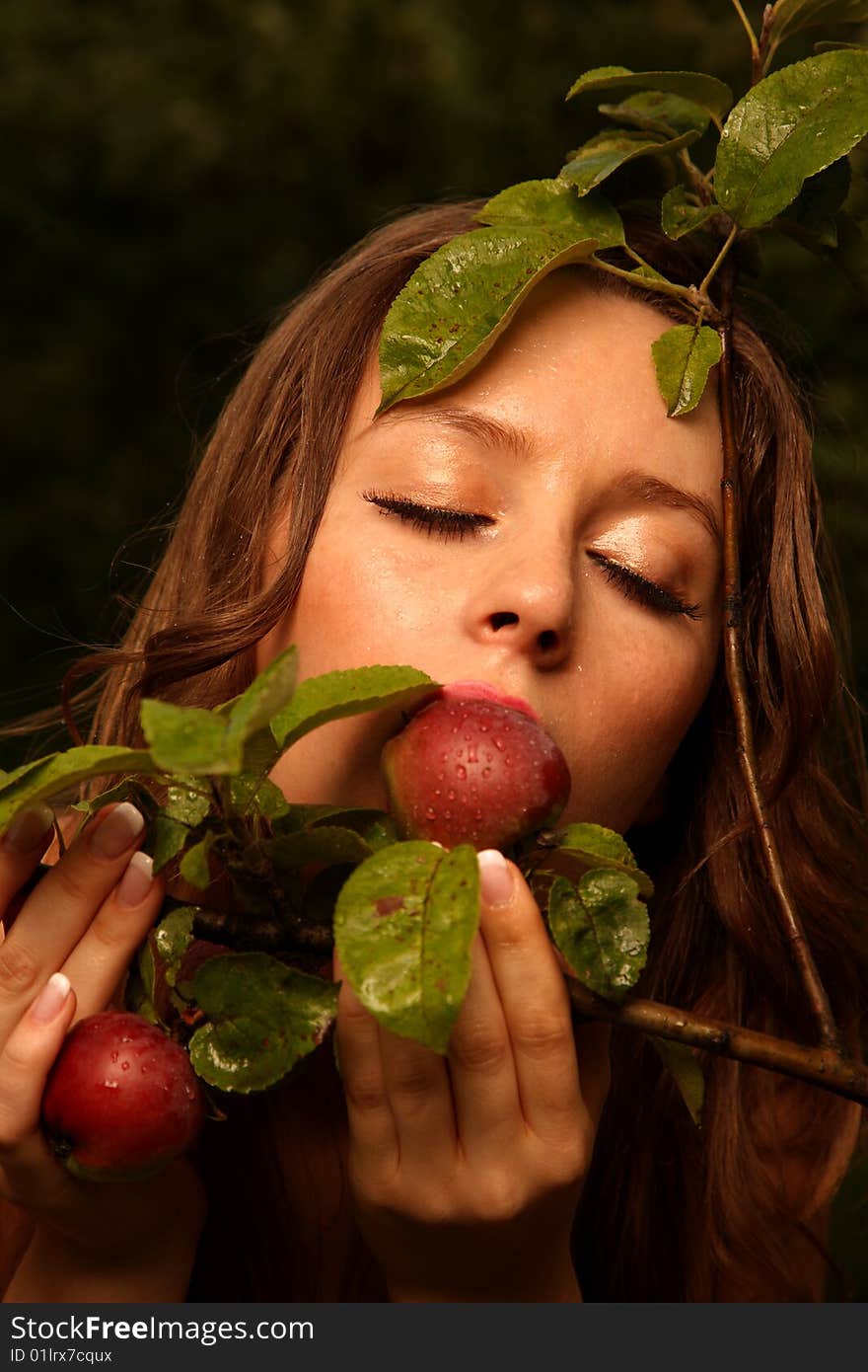 Woman eating apple with tree branch