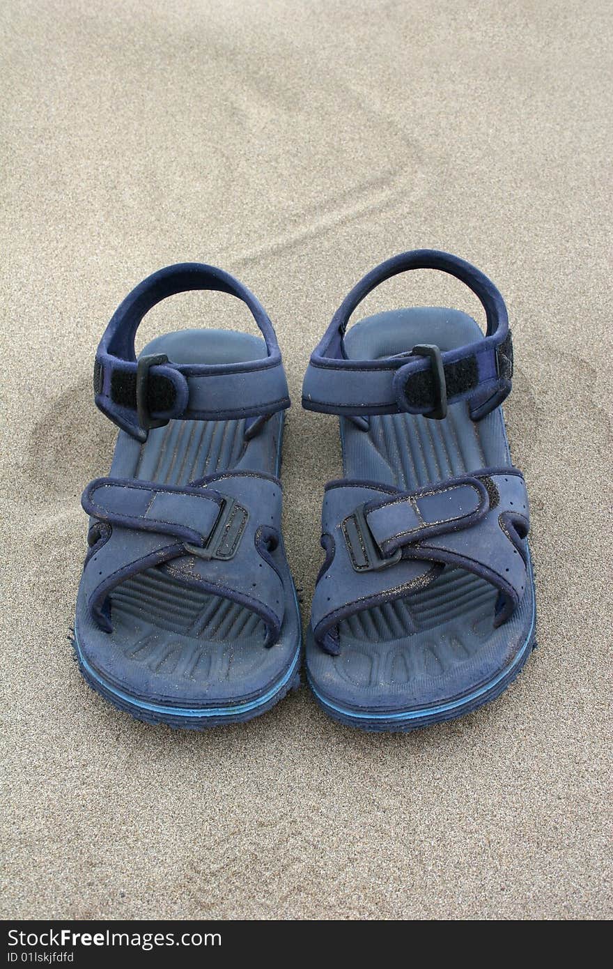 Blue beach sandals on the sand
