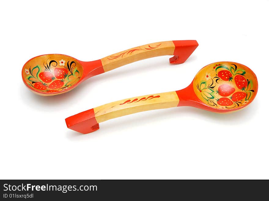 Two wooden Russian hand-painted spoons with curved handles on white background. Two wooden Russian hand-painted spoons with curved handles on white background