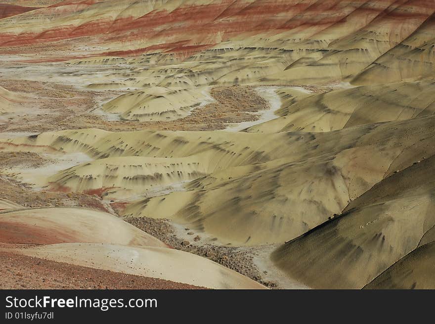 Painted Hills is one of the three units of the John Day Fossil Beds National Monument, located in Wheeler County, Oregon. It totals 3,132 acres (1,267 ha) and is located 9 miles (14 km) northwest of Mitchell, Oregon and 75 miles (121 km) east of Bend.Painted Hills is named after the colorful layers of its hills corresponding to various geological eras, formed when the area was an ancient river floodplain.

The black soil is lignite that was vegetative matter that grew along the floodplain. The grey coloring is mudstone, siltstone, and shale. The red coloring is laterite soil that formed by floodplain deposits when the area was warm and humid.