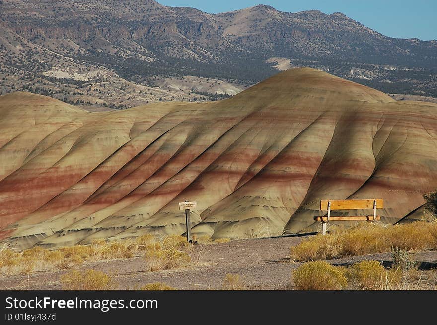 Painted Hills is one of the three units of the John Day Fossil Beds National Monument, located in Wheeler County, Oregon. It totals 3,132 acres (1,267 ha) and is located 9 miles (14 km) northwest of Mitchell, Oregon and 75 miles (121 km) east of Bend.Painted Hills is named after the colorful layers of its hills corresponding to various geological eras, formed when the area was an ancient river floodplain. The black soil is lignite that was vegetative matter that grew along the floodplain. The grey coloring is mudstone, siltstone, and shale. The red coloring is laterite soil that formed by floodplain deposits when the area was warm and humid.