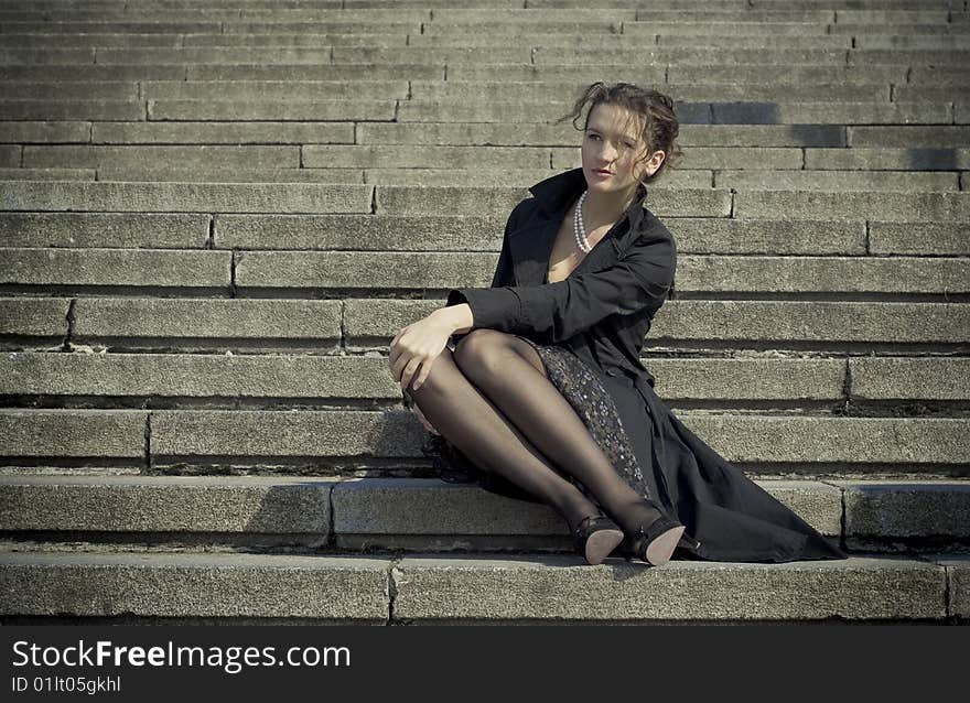 Beautiful girl sits on a stair