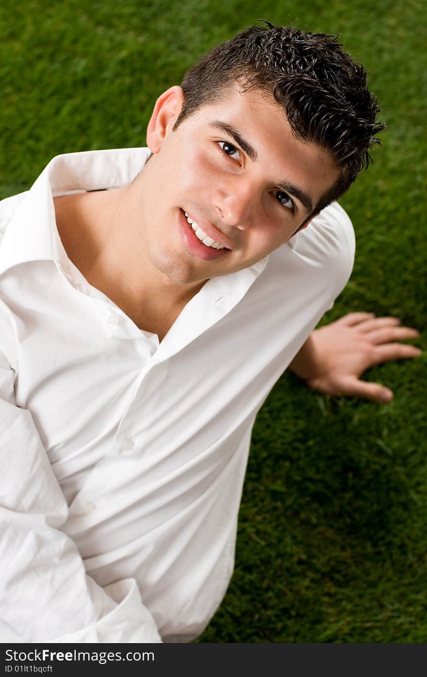 Young handsome man relaxing outdoor on green grass. Young handsome man relaxing outdoor on green grass