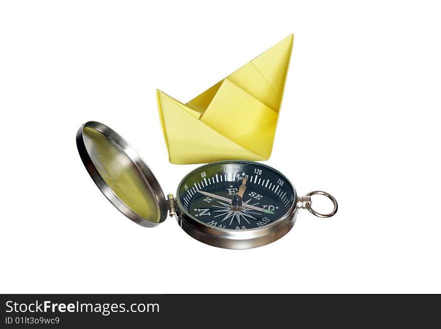 Yellow paper boat standing near compass isolated on white background with clipping path. Yellow paper boat standing near compass isolated on white background with clipping path