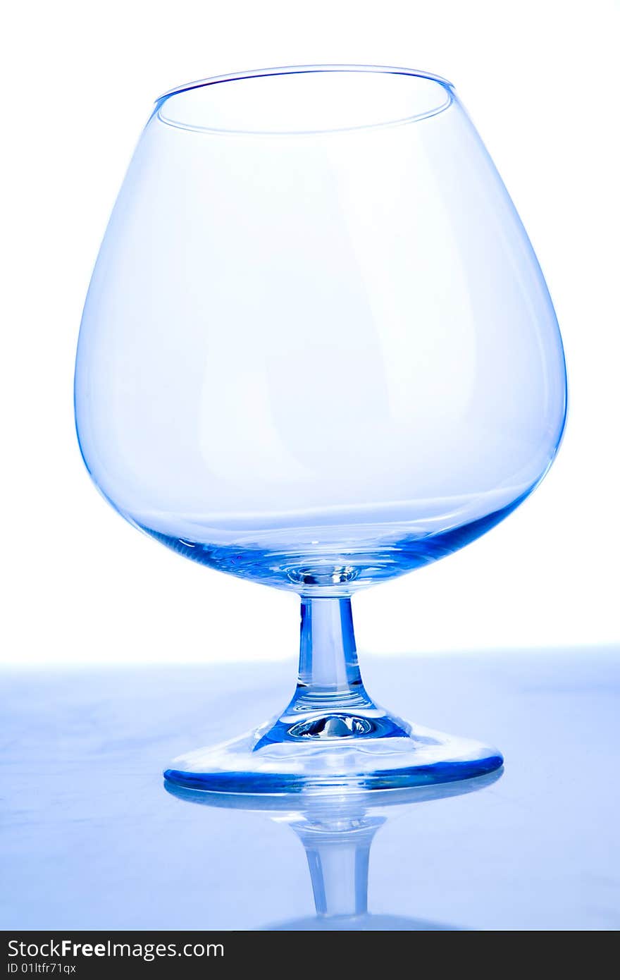 Empty cognac glass on white ground