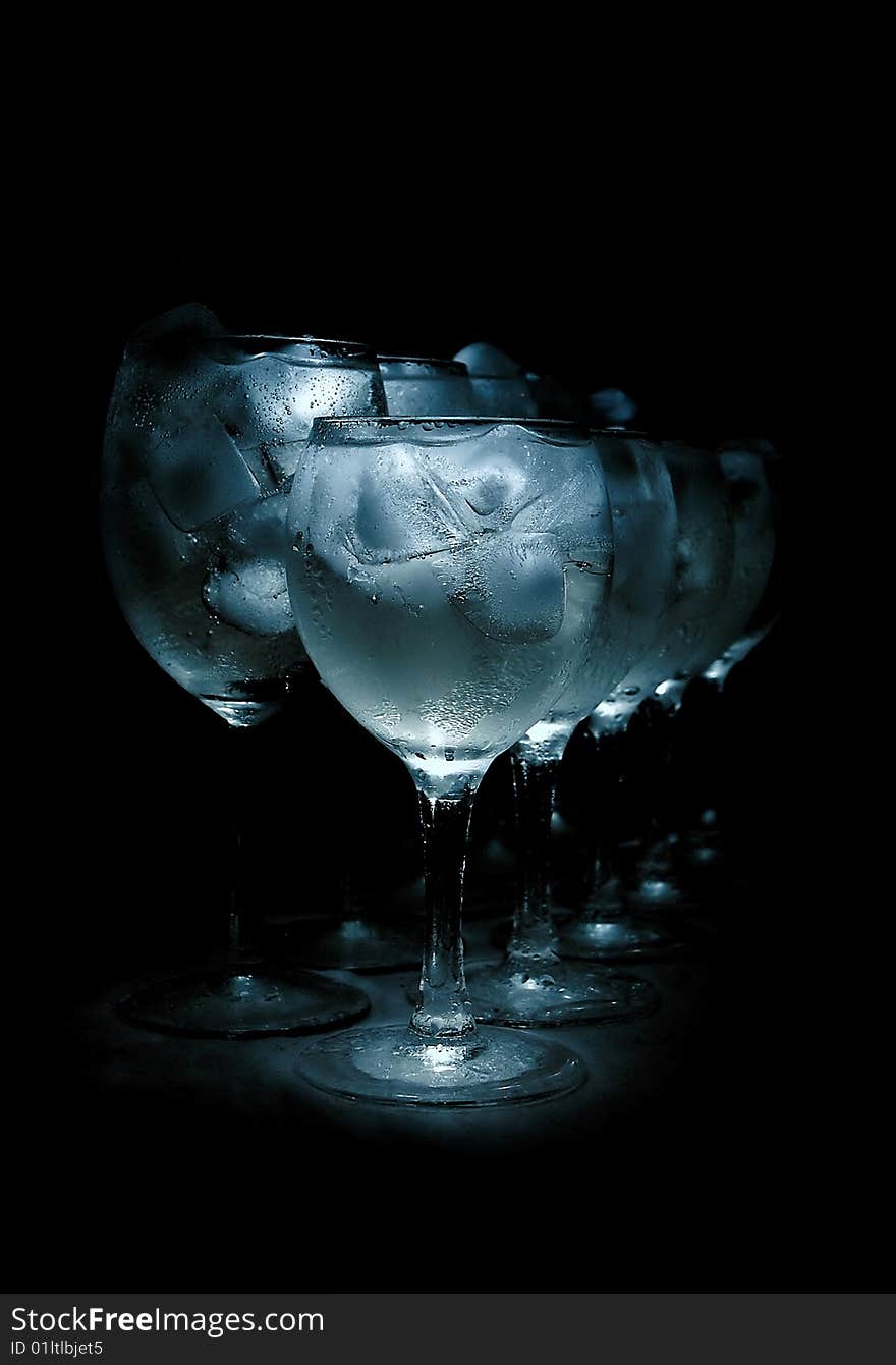 Glasses with ice cubes isolated over black background. Glasses with ice cubes isolated over black background