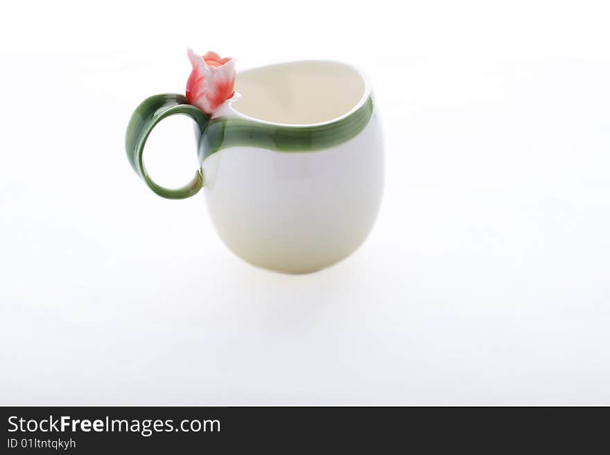 Isolated cup decorated with red flower and green stripe. Isolated cup decorated with red flower and green stripe