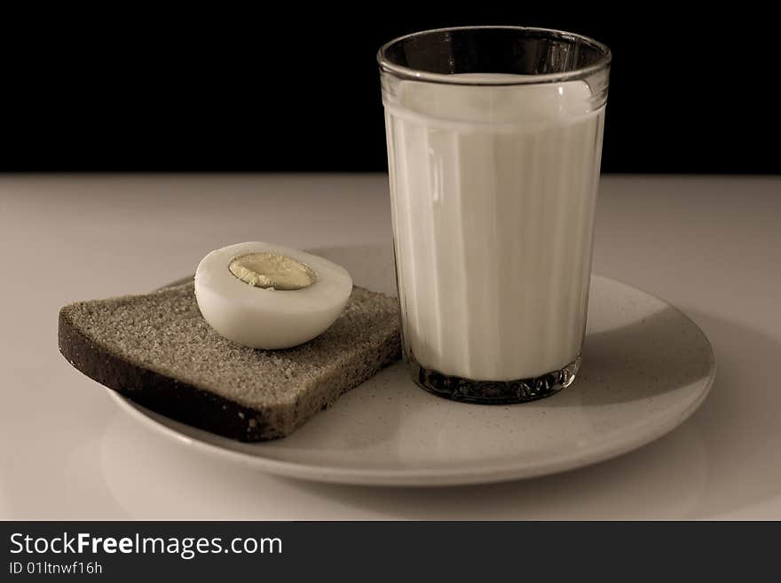 A half egg, a slice of bread, and a glass of milk. A half egg, a slice of bread, and a glass of milk