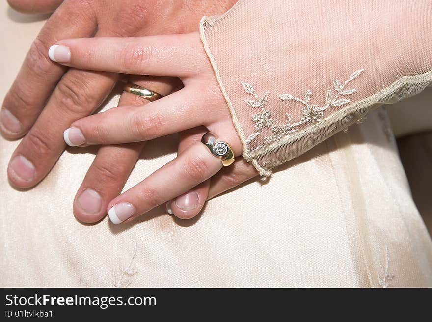 Groom holding his new bride's arm gently. Groom holding his new bride's arm gently