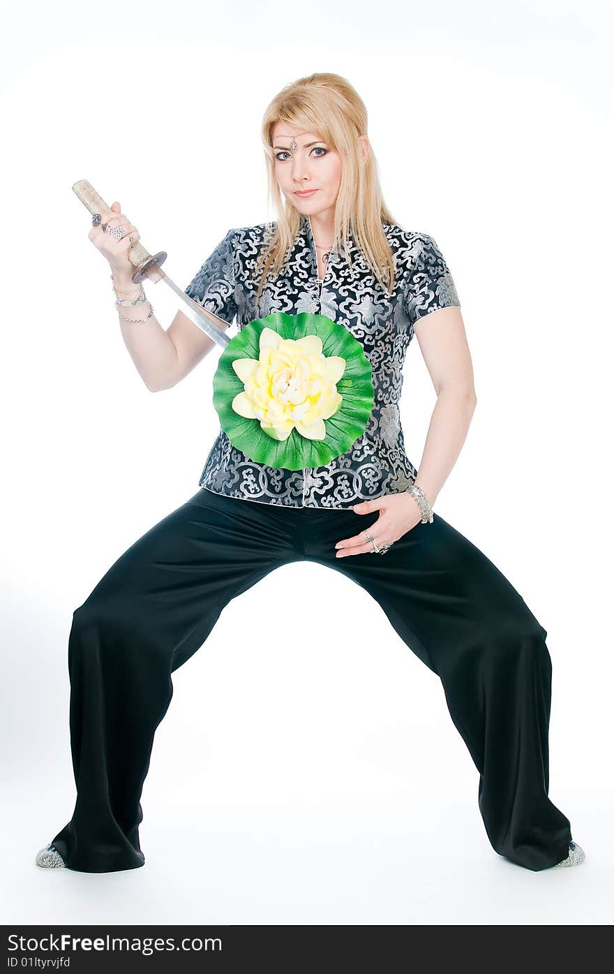 Woman with sword and lotus flower, studio shot