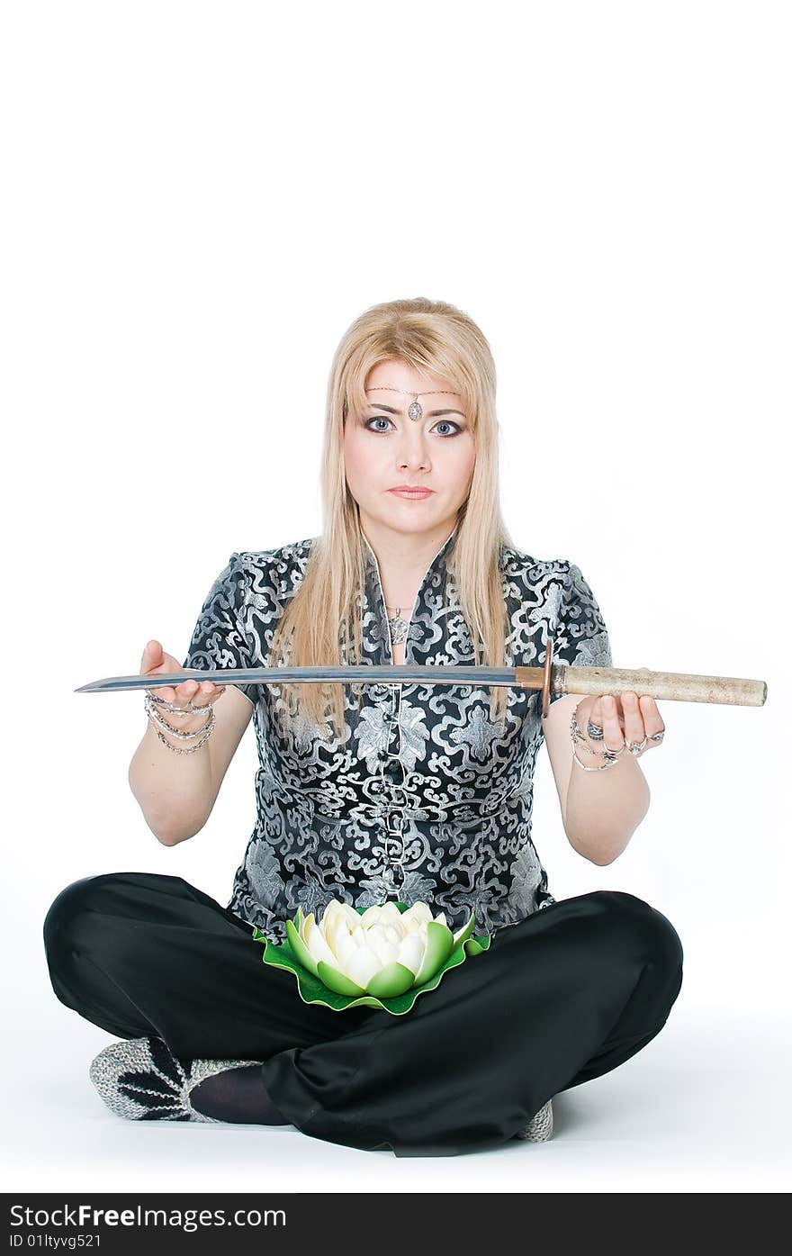 Woman sitting in lotus pose with katana, isolated on white background