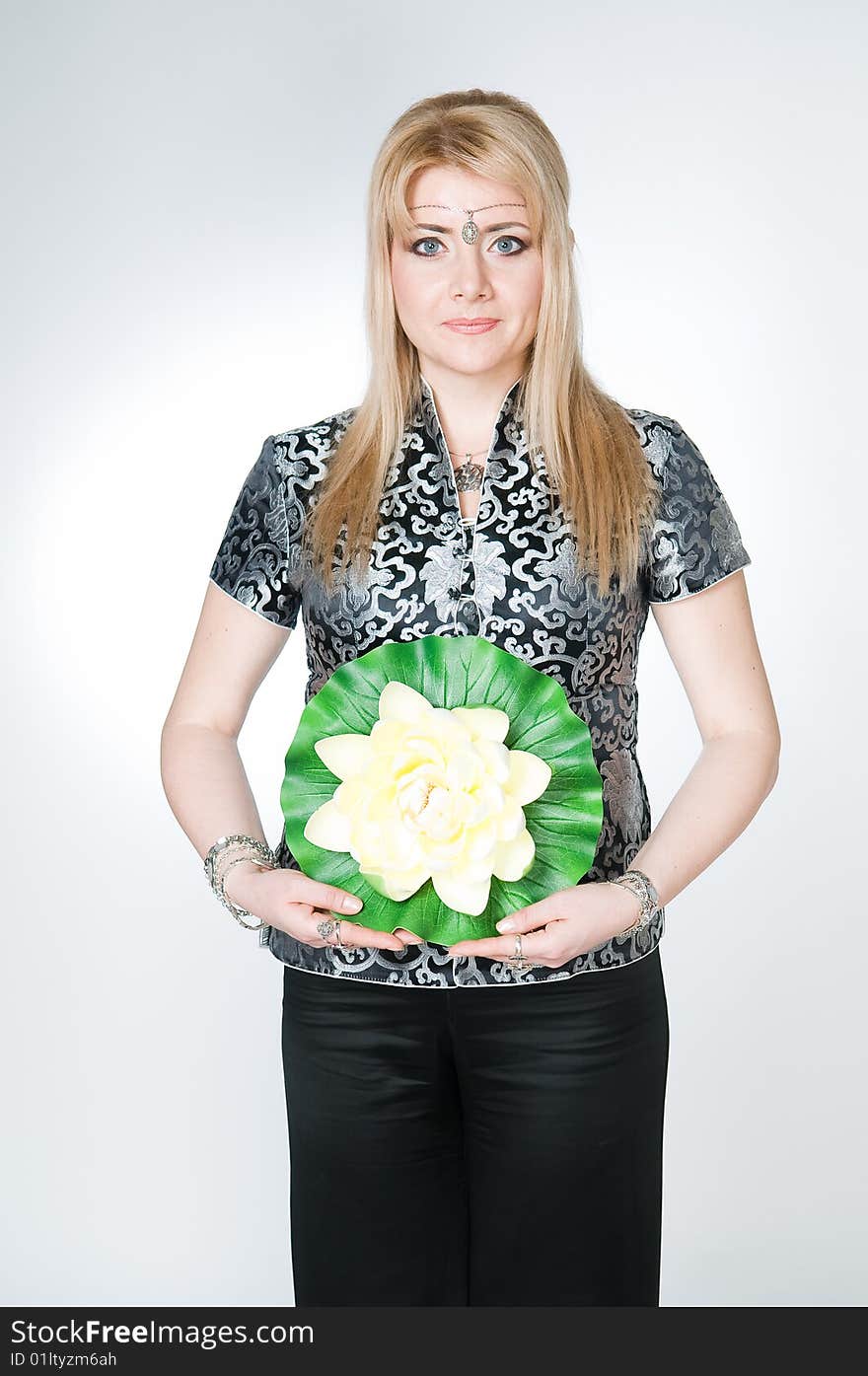 Woman with lotus flower, studio shot