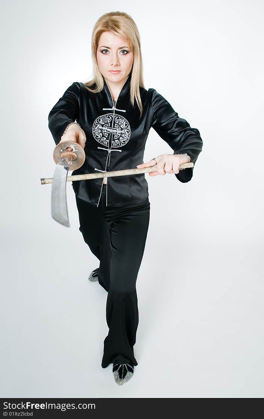 Attractive woman in Japanese shirt with sword, studio shot