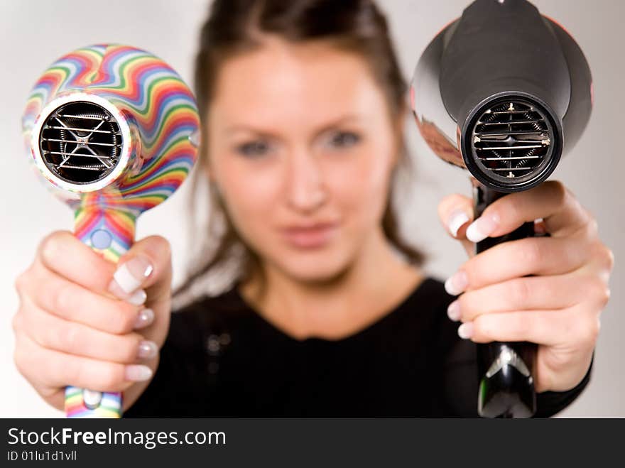 Young attractive woman with two hairdryers. Young attractive woman with two hairdryers