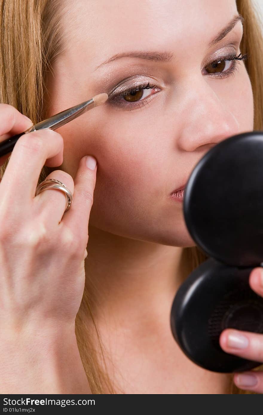 Nice caucasian model applying makeup with brush. Nice caucasian model applying makeup with brush