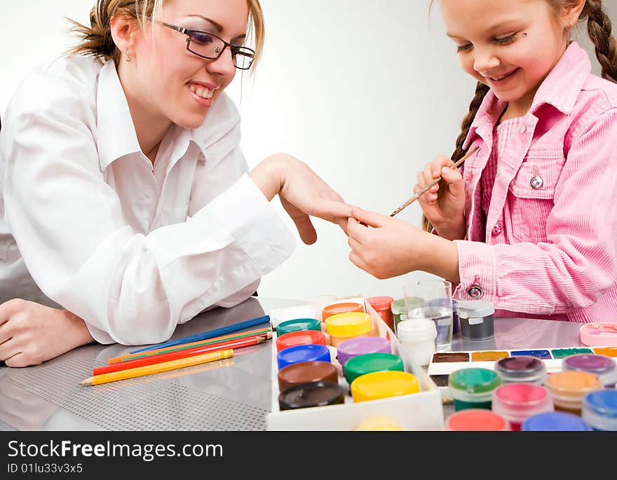 Little girl playing with mom, painting her fingers. Little girl playing with mom, painting her fingers