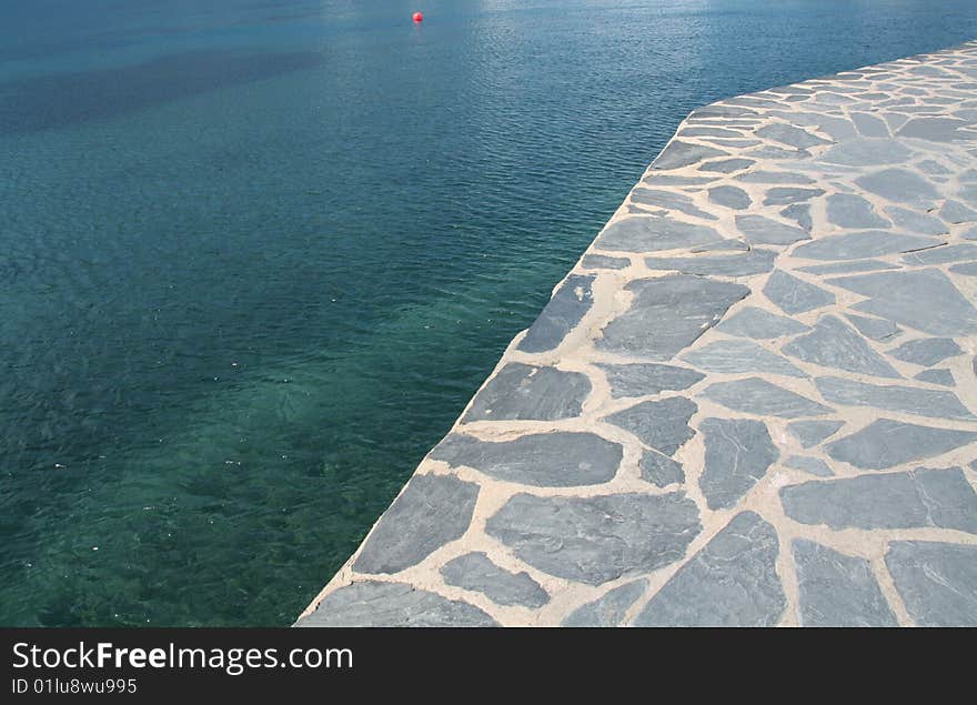 Blue sea and a stone promenade at the coast. Blue sea and a stone promenade at the coast