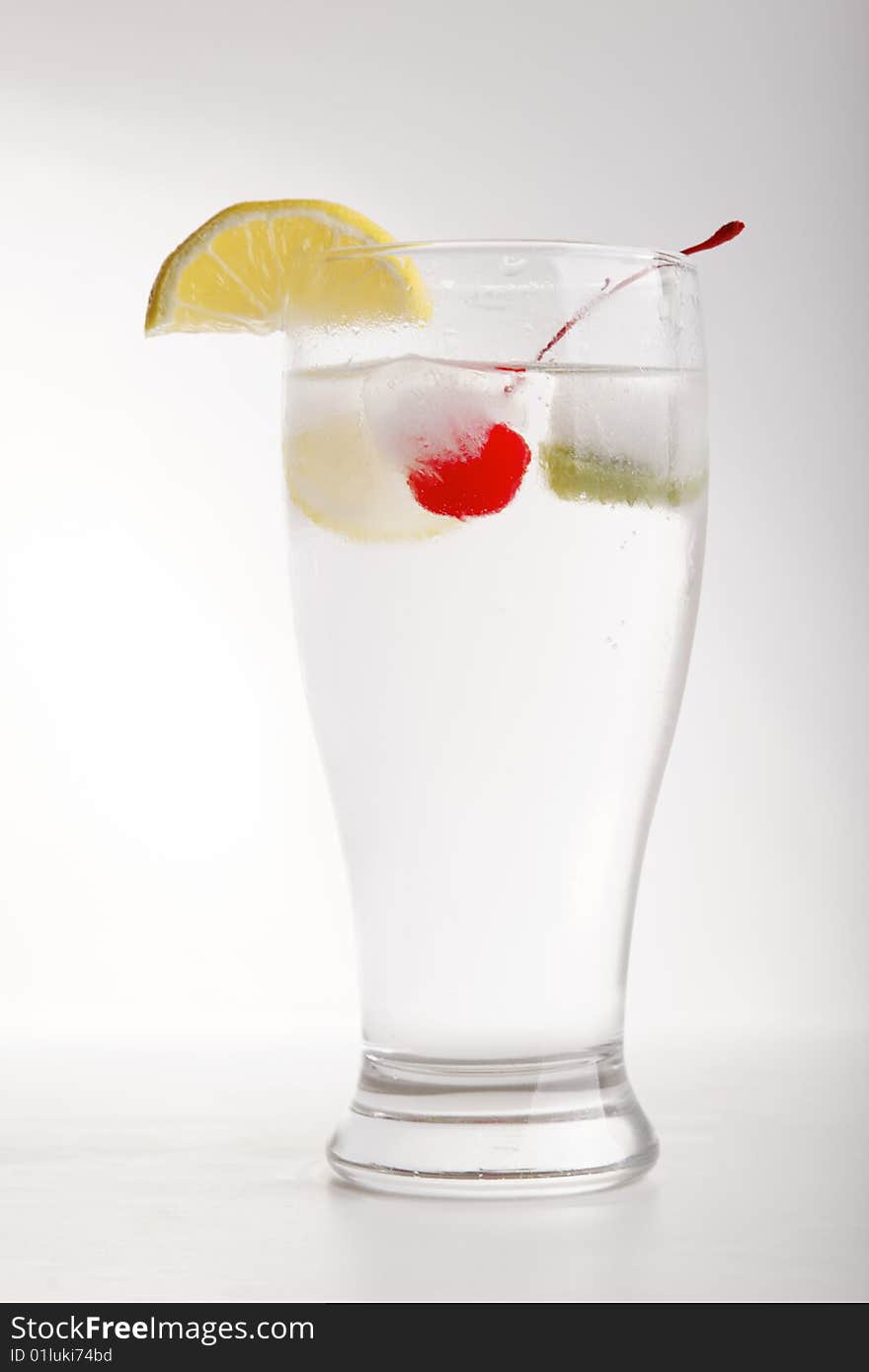 Glass of water with frozen fruit inside the ice cube. Glass of water with frozen fruit inside the ice cube