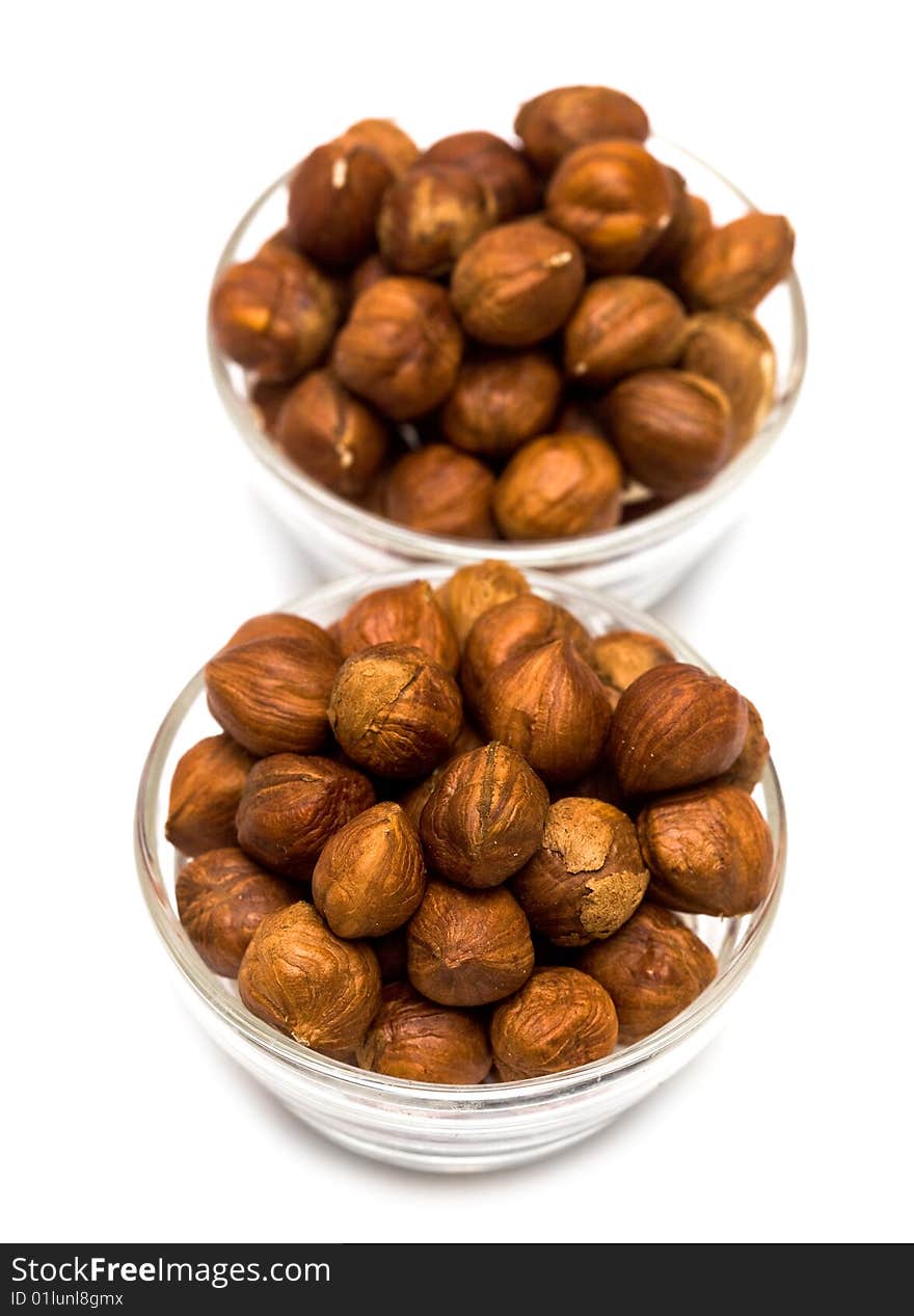 Many hazelnuts in glass bowls