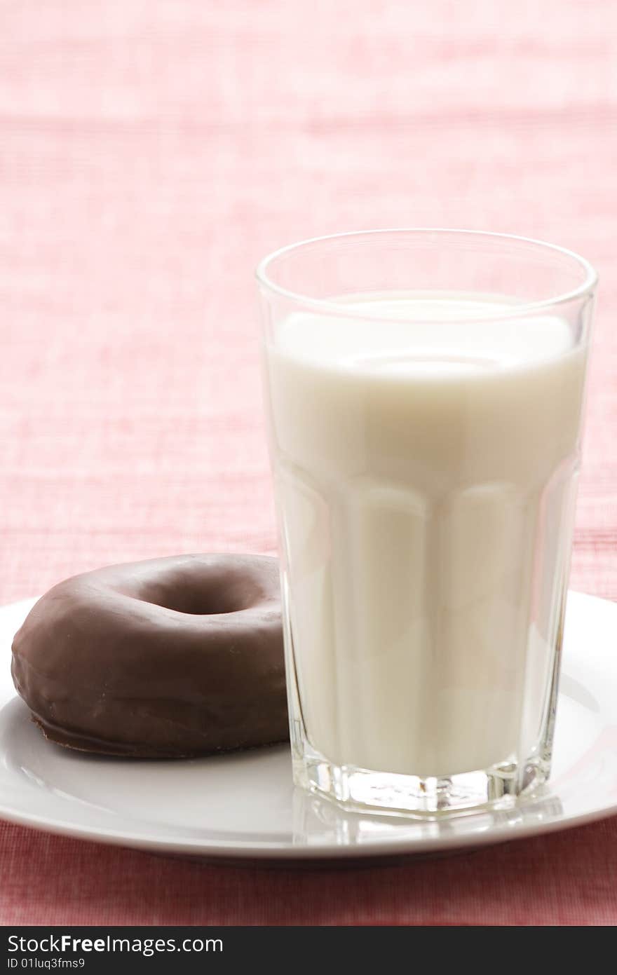 Breakfast glass of chocolate milk and donut isolated