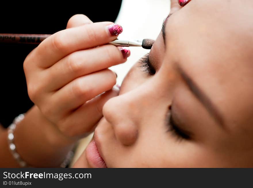 Putting on eye shadow with a brush for an event. Putting on eye shadow with a brush for an event