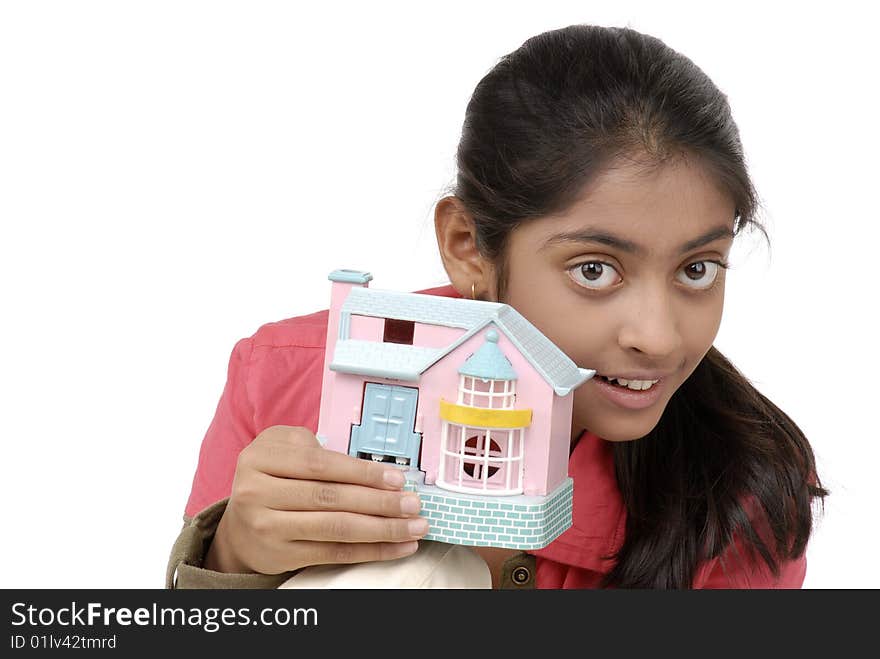 Beautiful girl holding dream model house over white background. Beautiful girl holding dream model house over white background