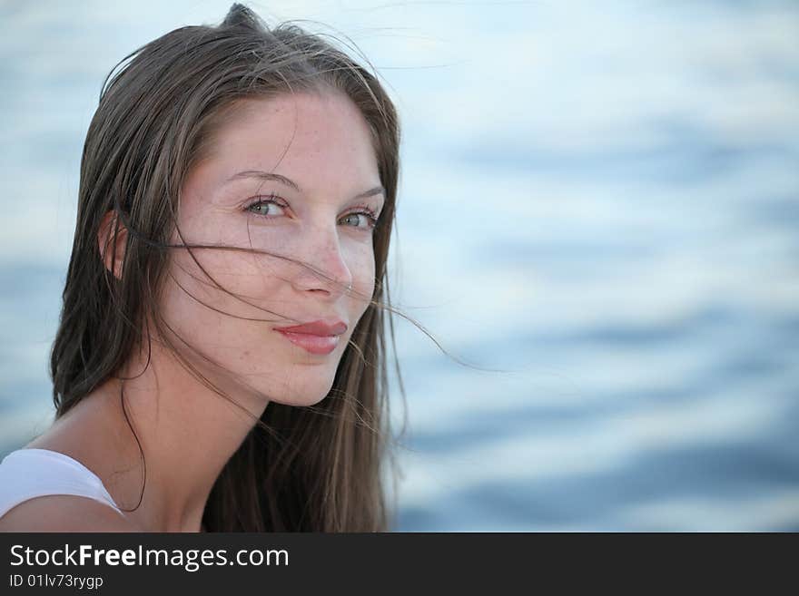 Portrait of beautiful young woman on water background