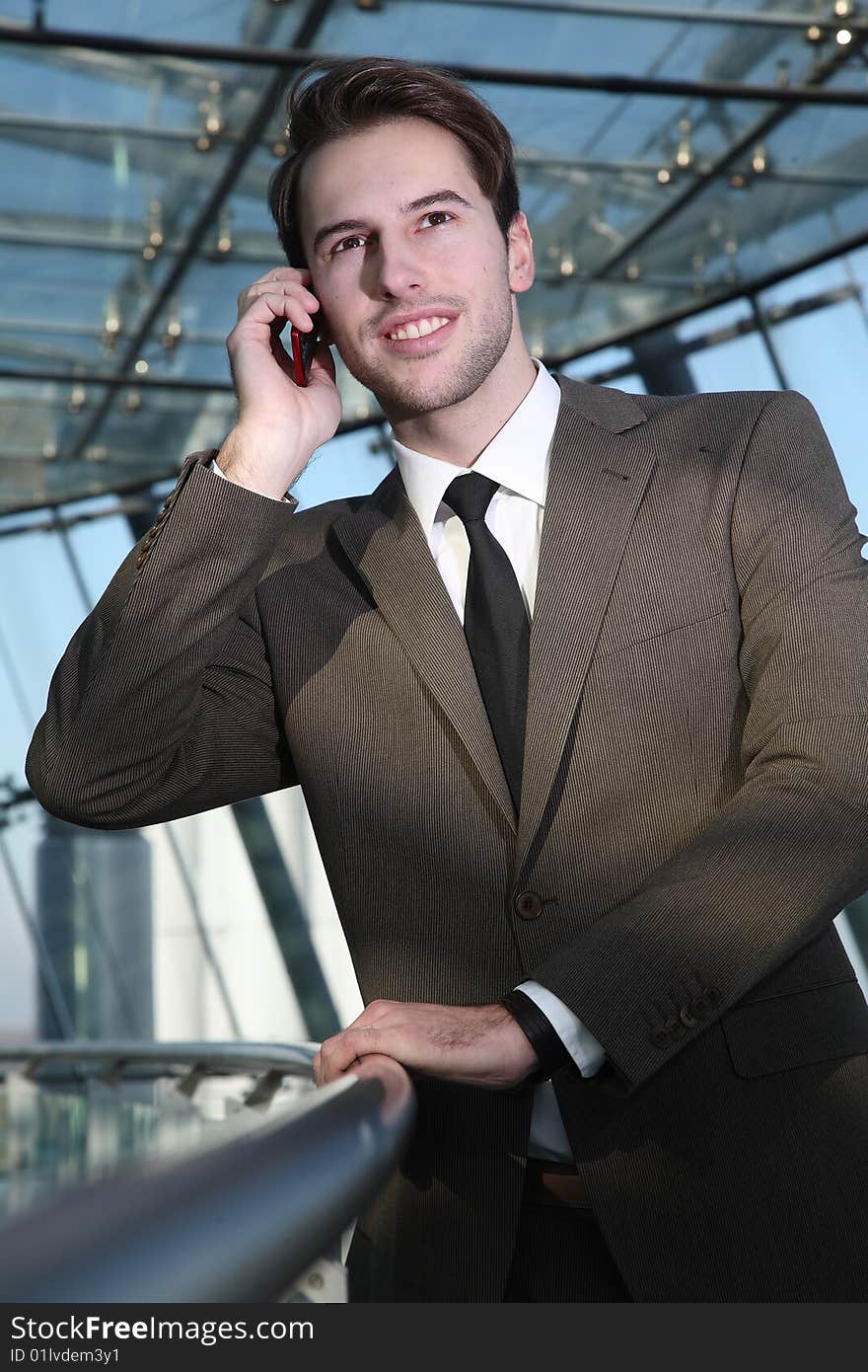 Man in suit stands with telephone. Man in suit stands with telephone