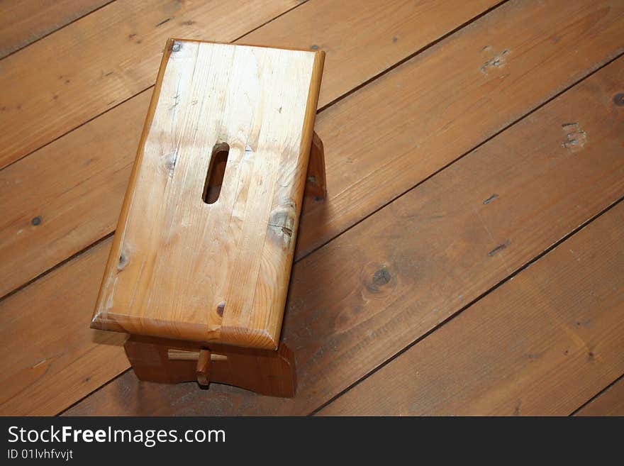 It's a wood stool on a wood bacground. It's a wood stool on a wood bacground.