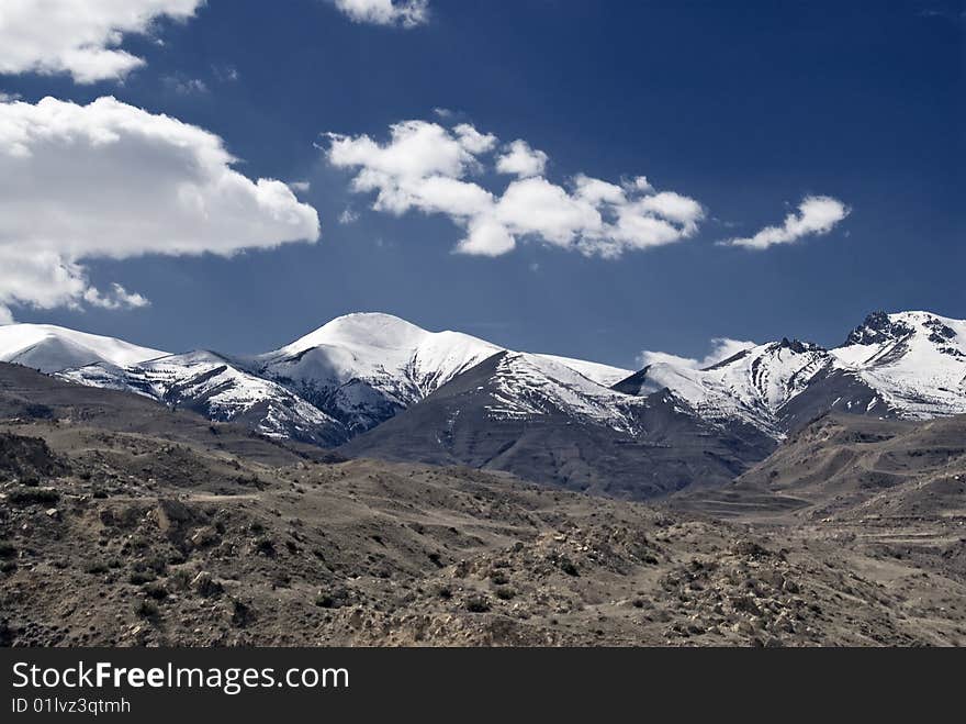 Snowcapped mountains with white clouds.